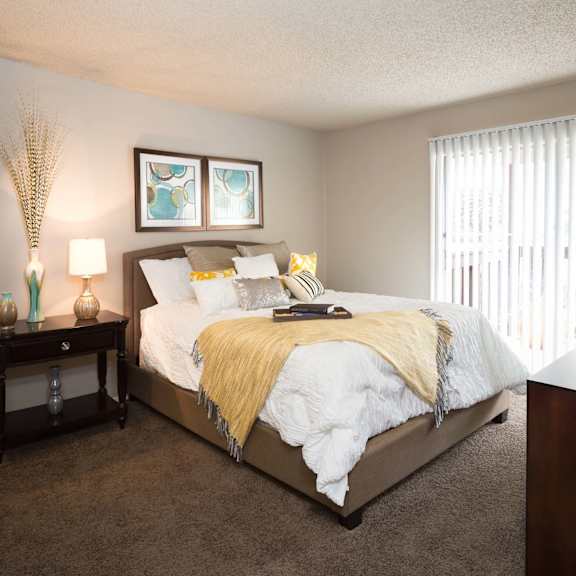 a bedroom with a bed and a chair and a window