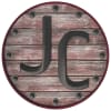 a round wooden sign with the letters jc