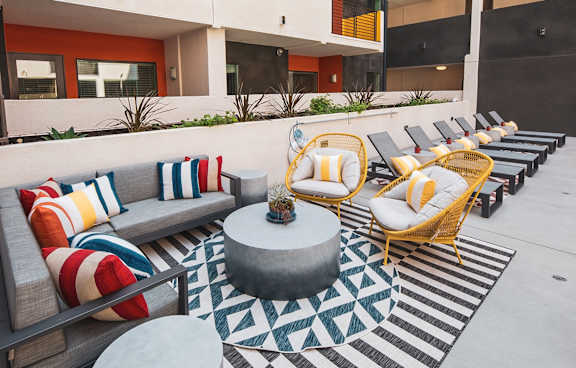 Multiple lounge chairs by the pool at Sora Apartments, Inglewood, 90302