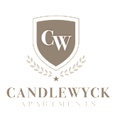 The image is a logo for Candlewycz Apartments, featuring a shield with the letters "CW" and a laurel wreath.