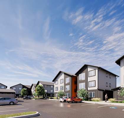 A modern apartment complex with a parking lot in front.