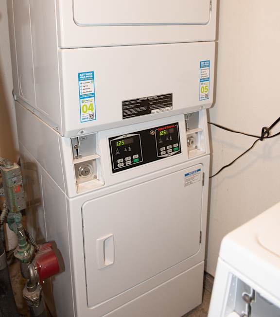 A white tankless water heater with a digital display and a blue sticker on the side.