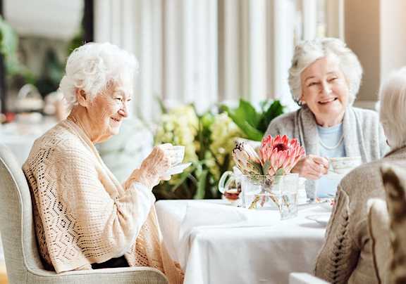 two elderly women sitting at a table in a restaurant