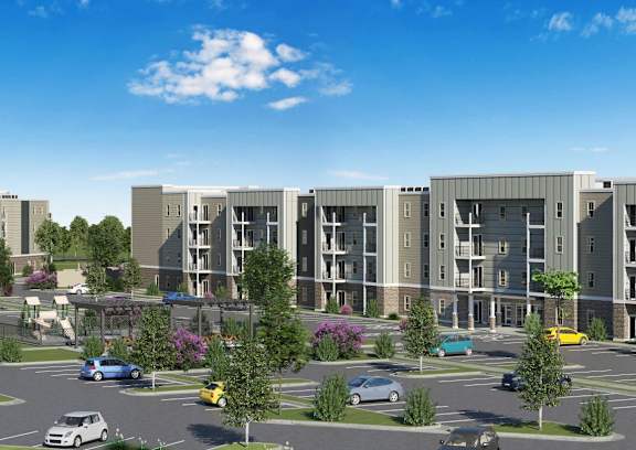 an aerial view of an apartment complex with cars in a parking lot