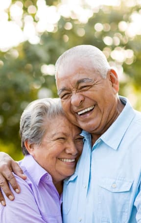 an older man and woman embracing each other on a bench