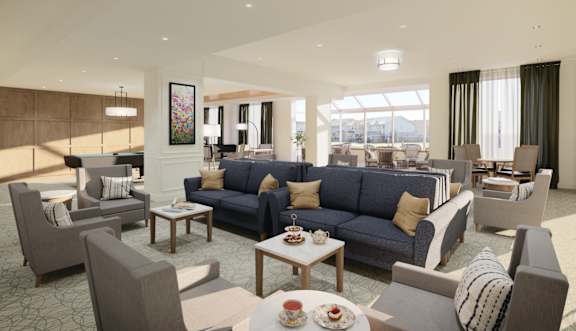 Sitting area with couches, tables, and chairs with natural lighting.