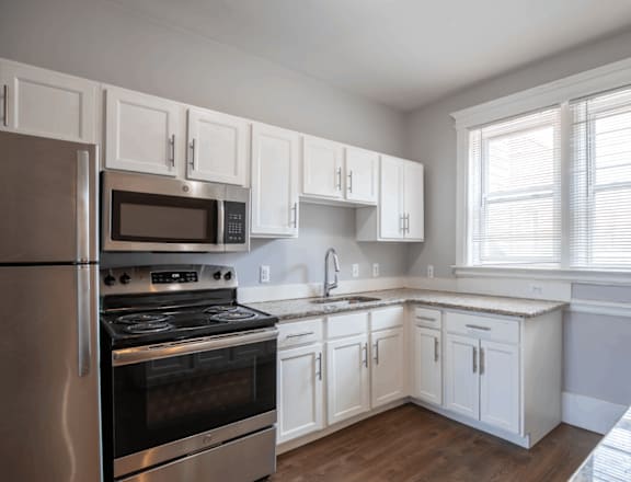 a kitchen with white cabinets and stainless steel appliances