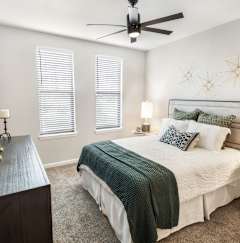 a bedroom with a white bed and two paintings on the wall