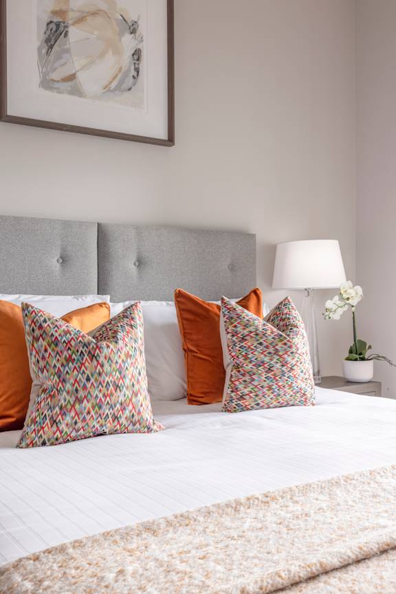 a bedroom with a large bed with pillows on it
