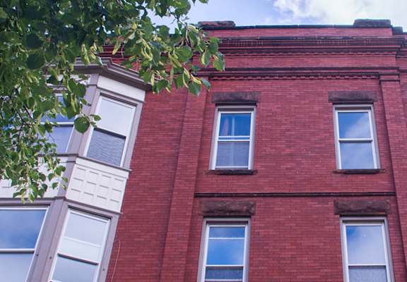 red brick apartment building with massive windows at 231 West Ave in Buffalo, NY