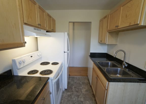 a kitchen with white appliances and wooden cabinets