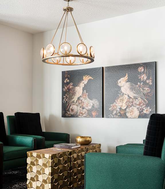 A room with a green chair and a gold box on the floor.