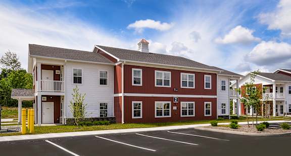 A red and white building with a parking lot in front.