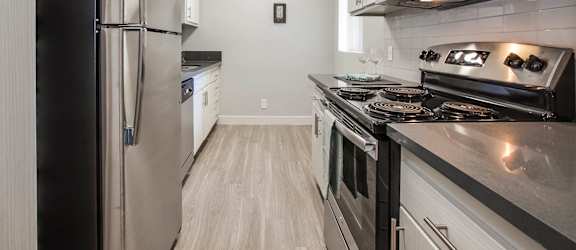 a kitchen with stainless steel appliances and white cabinets at Candlewood North, Los Angeles, California