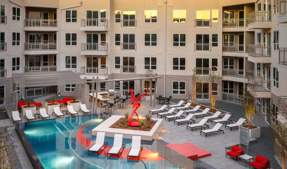 an aerial view of an apartment complex with a pool and lounge chairs