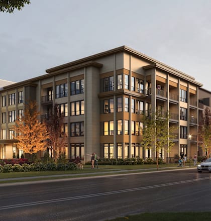 A modern apartment building with cars parked in front.