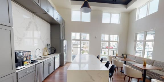 the kitchen and dining area of an open floor plan with a large white counter top at The Fitzroy San Marcos, San Marcos, TX