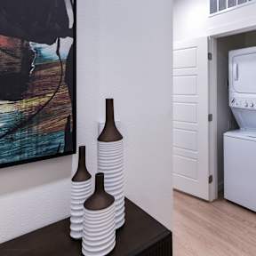 a white washer and dryer in a room with a door to a bathroom