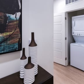 a white washer and dryer in a room with a door to a bathroom