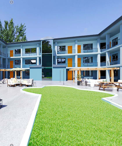 a grassy courtyard with a couch and chairs in front of a building