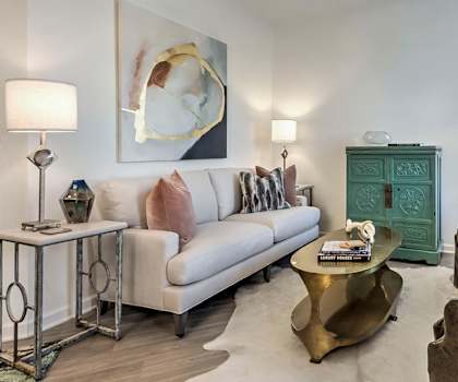 A living room with a white couch, a green cabinet, and a gold coffee table. at Residence at Tailrace Marina, North Carolina