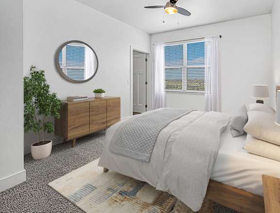 A bedroom with a bed, nightstand, and a plant