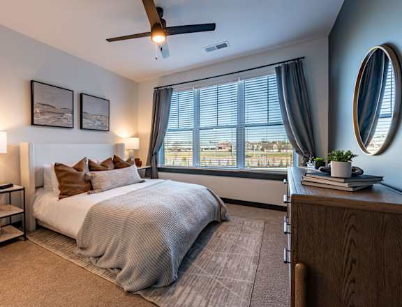 a bedroom with a large window and a bed