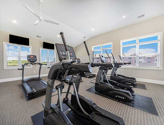 a gym with cardio machines and windows at Trade Winds Apartment Homes in Elkhorn, NE 68022