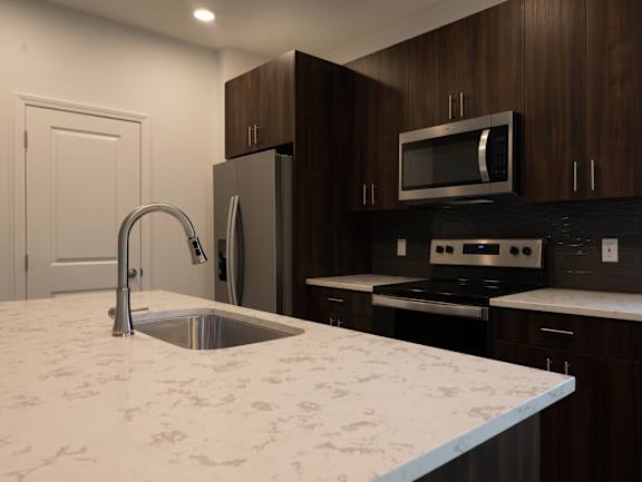 a kitchen with a marble counter top and a sink at The Clearing at ONE28, Olathe, 66062