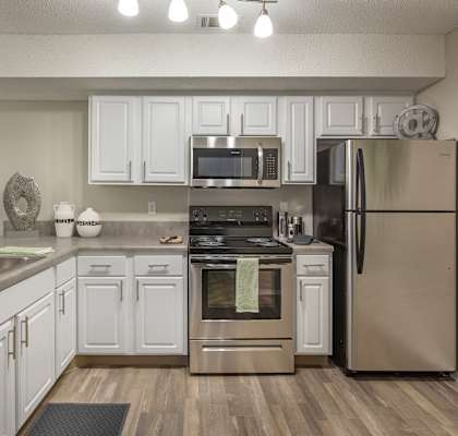 a kitchen with white cabinets and stainless steel appliances