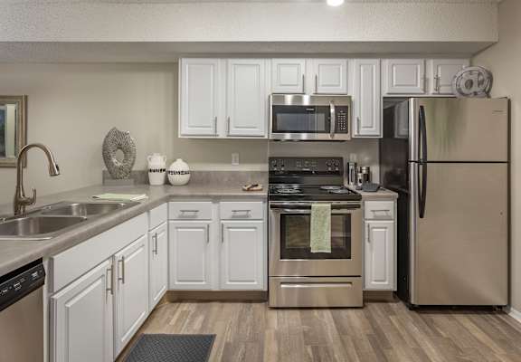 a kitchen with white cabinets and stainless steel appliances