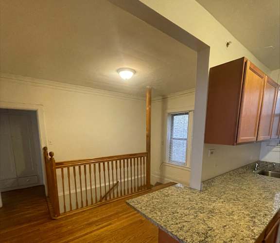 A kitchen with wooden cabinets and a granite countertop.