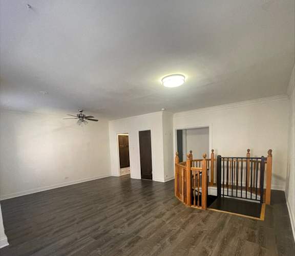 A room with wooden floors and a ceiling fan.
