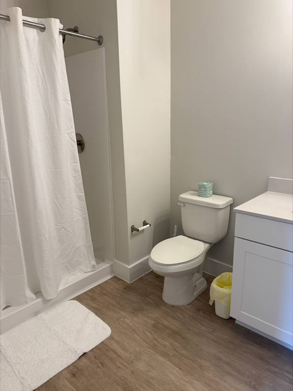 A white toilet sits next to a white sink in a small bathroom.