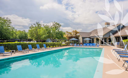 Stonesthrow Apartments Clubhouse Exterior and Pool with Lounge Chairs