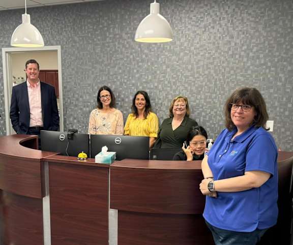 A group of people standing in front of a reception desk.