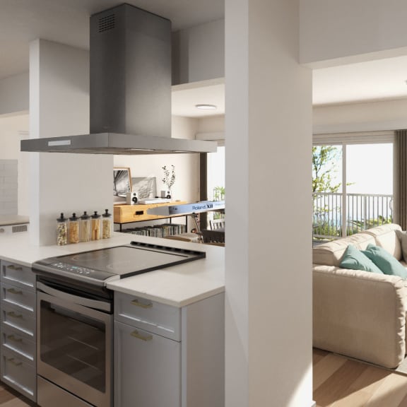 A modern kitchen with a large island and a living room with a couch at Ocean Edge @ Laguna Beach Apartments, California, 92651