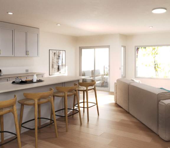 a living room with a couch and a bar with stools at Ocean Edge @ Laguna Beach Apartments, Laguna Beach