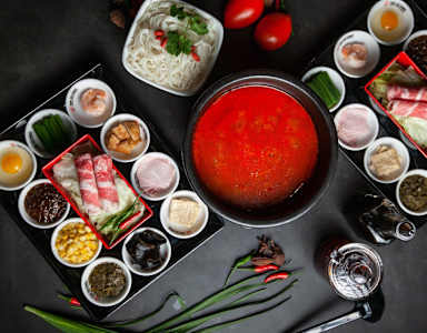 A variety of Asian food is arranged on a black surface.