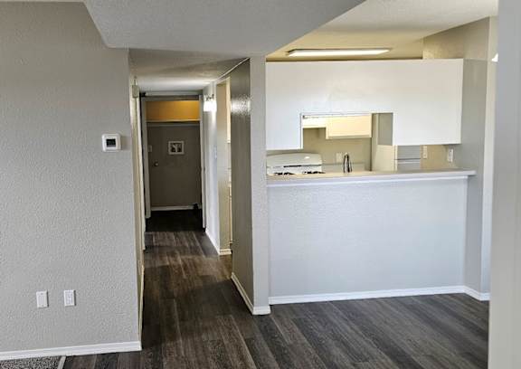 A hallway with a white reception desk and a mirror on the wall.