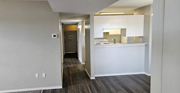 A hallway with a white reception desk and a mirror on the wall.