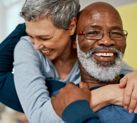 a man and a woman hugging and smiling.