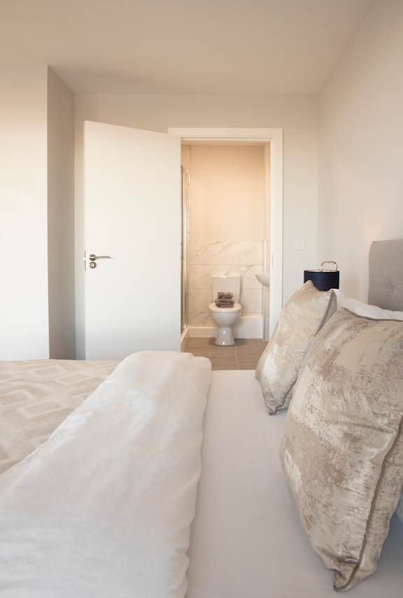 a bedroom with a bed and a bathroom with a toilet