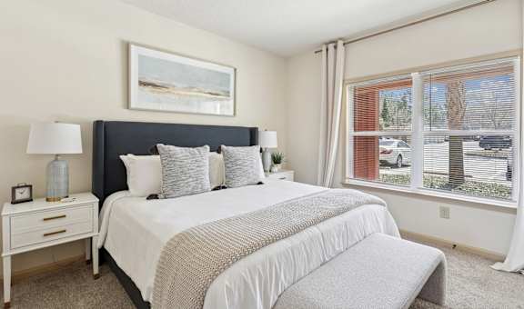 Bright bedroom with large window and plush bedding at Tattersall Village Apartments near Savannah, GA