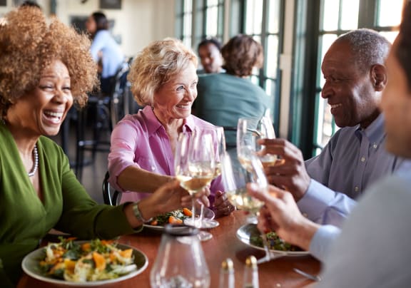 A group of people sitting around a table eating and drinking wine at The Dorchester & Manor, NC, 28134