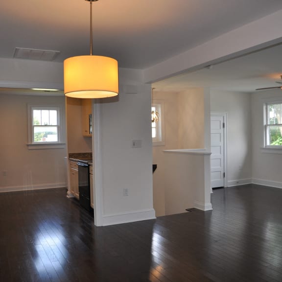 an empty living room with a window and a ceiling fan