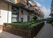 Thumbnail 3 of 4 - a row of apartment buildings on a street with a sidewalk