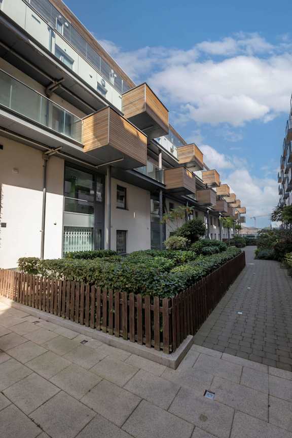 a row of apartment buildings on a street with a sidewalk