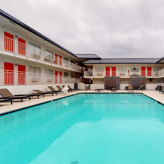 A large indoor swimming pool with lounge chairs on the side.