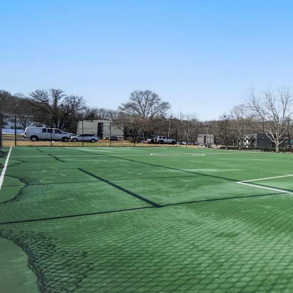 A tennis court with a green surface and white lines.